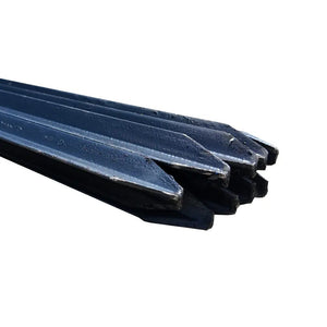 Black metal fence posts with pointed ends stacked together for outdoor fencing