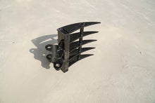 Rippa Australia black Excavator Rake attachment with curved tines on concrete surface