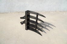 Rippa Australia black metal Excavator Rake attachment with four curved tines on concrete surface